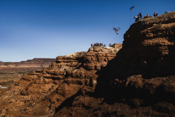 Establishing profile shot of huge front flip off cliff in red bull rampage.