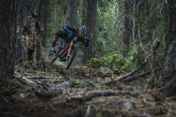 Man ridding super aggressively on forest mountain bike trial.