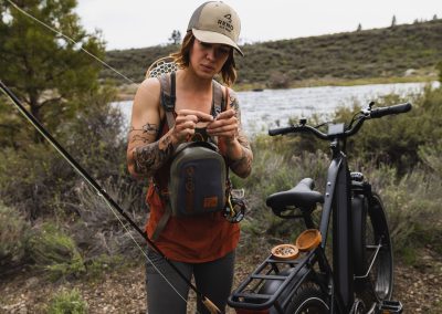 Woman preparing her fishing line before fly fishing withe-bike in shot.