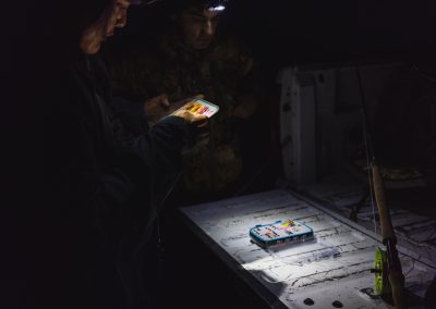 Photograph of woman looking at fly box preparing for fly fishing.