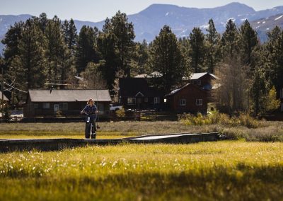 Establishing shot of woman riding e-bike in stunning outdoor setting.