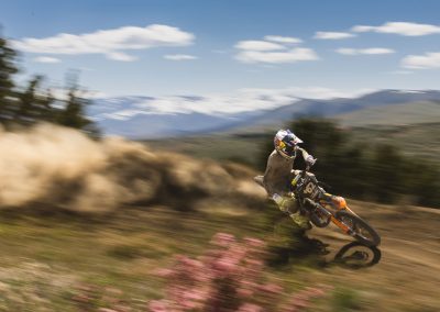 Male motocross rider going fast on dirt trail.