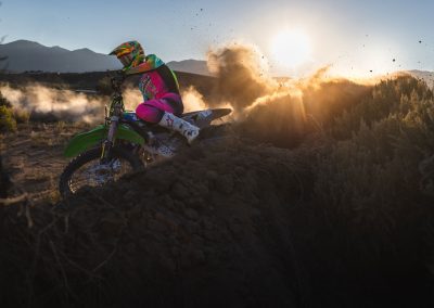 Motocross rider in race gear digging into a berm.