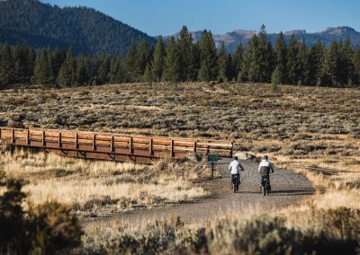 two people riding e-bike photographed from behind in great outdoors.