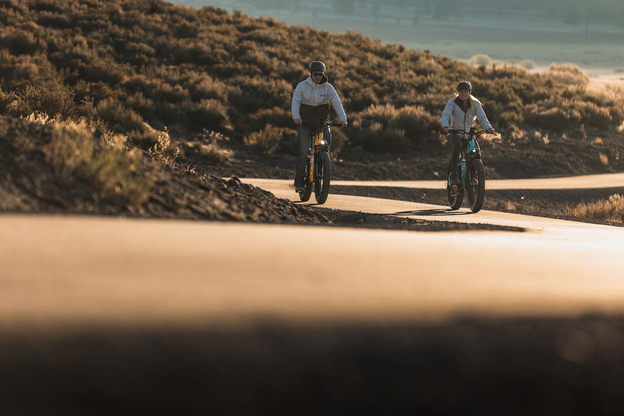 Man with mustache riding e-bike over rough muddy terain.