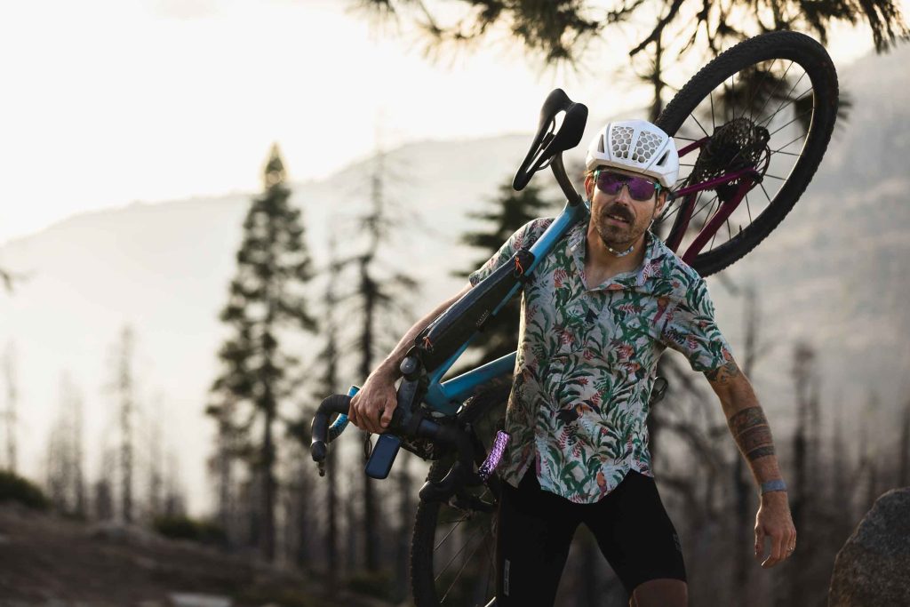 Endurance cyclist, Tyler Pearce, hiking rough terrain while carrying his Canyon gravel bike. Photo by Ryan Cleek